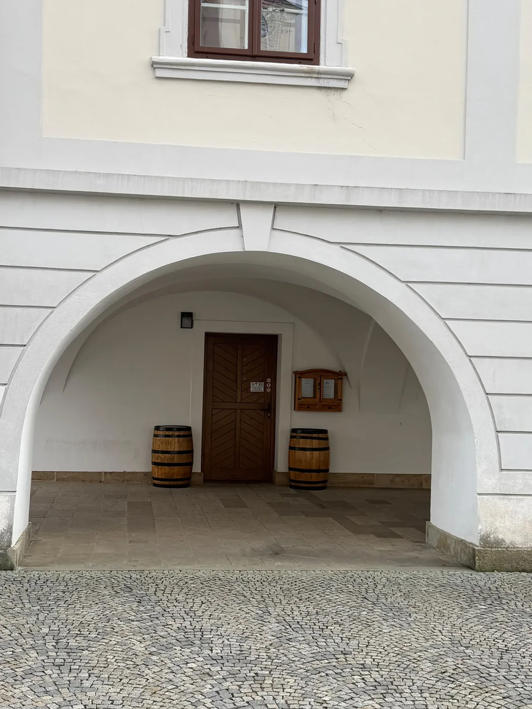 Vchod do hospůdky s dřevěnými dveřmi a vývěskou s jídelním lístkem